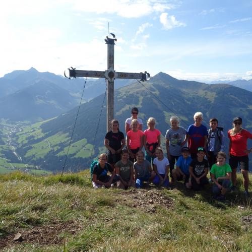 Kinder vor einem Gipfelkreuz