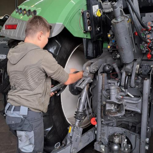 Junge repariert Traktor